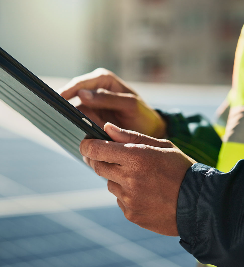 Technicien en maintenance photovoltaïque utilisant une tablette sur site