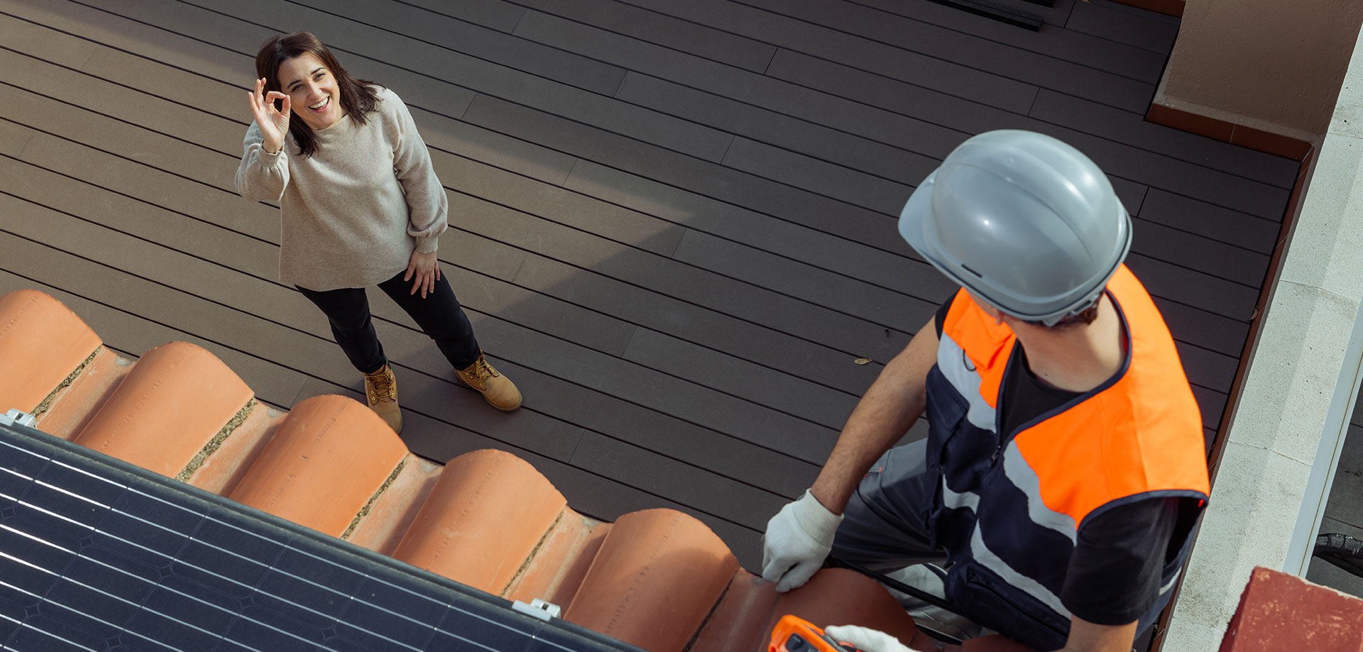 Technicien solaire sur le toit en discussion avec une cliente satisfaite