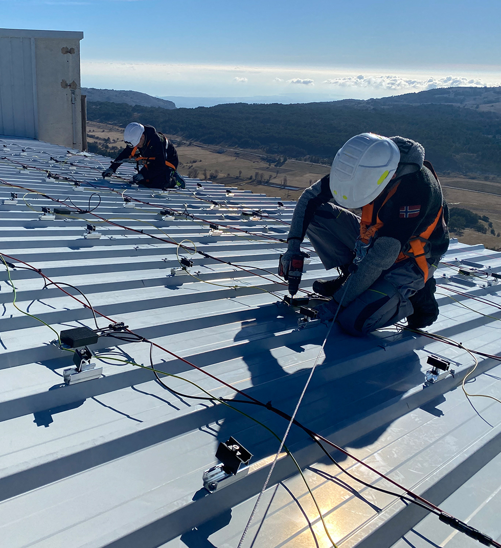 Techniciens d'une entreprise d'énergie renouvelable posant des panneaux photovoltaïques